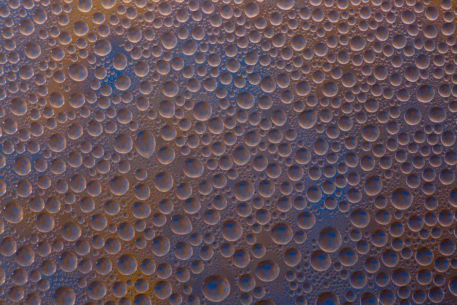 Detailed view of numerous water droplets forming a pattern on a surface.